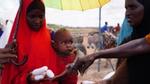 Woman with baby in Africa being handed bars of soap by volunteer