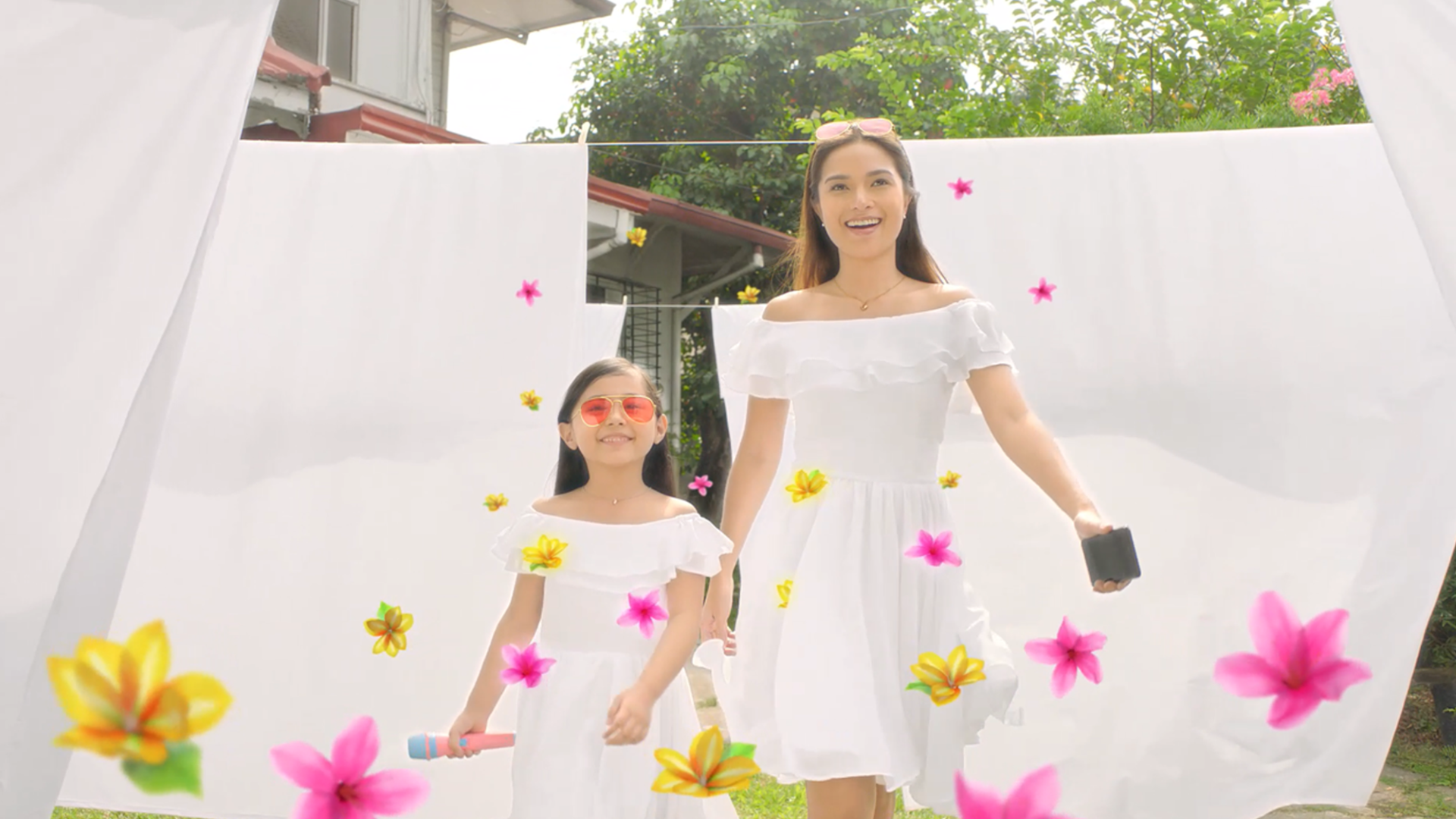 Mother and daughter outdoors, wearing white dress