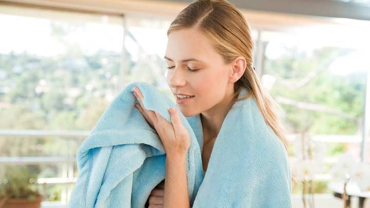 A lady smelling a towel