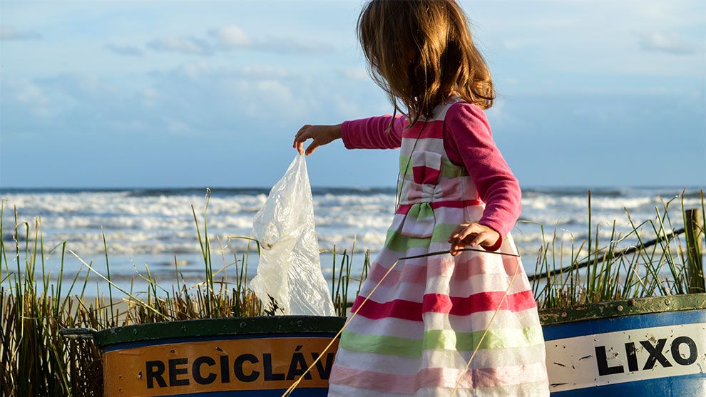 Young child picking up plastic bag