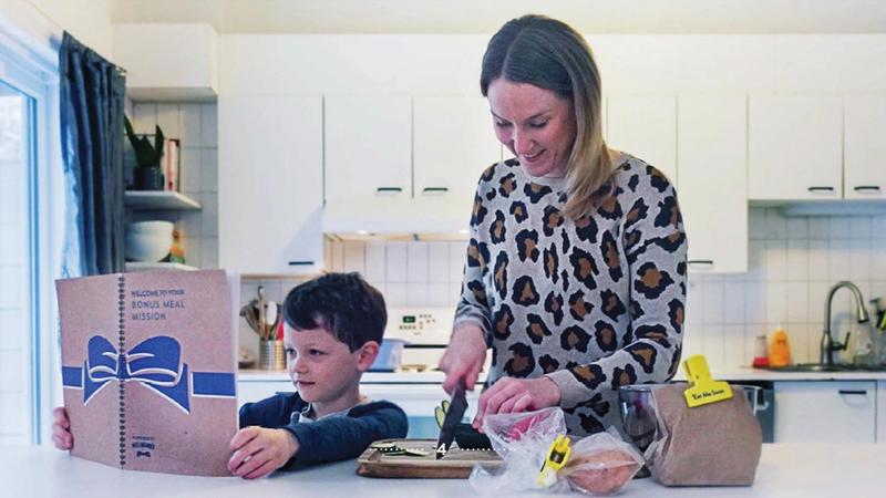 Parent and child cooking together in a household kitchen