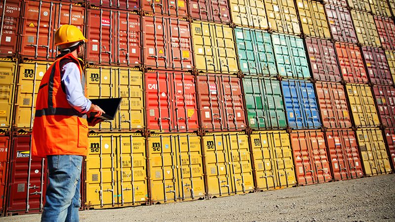 Worker monitoring a large number of piled containers