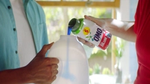 A dilute-at-home bottle of Persil/OMO laundry detergent is poured into a larger refill bottle.