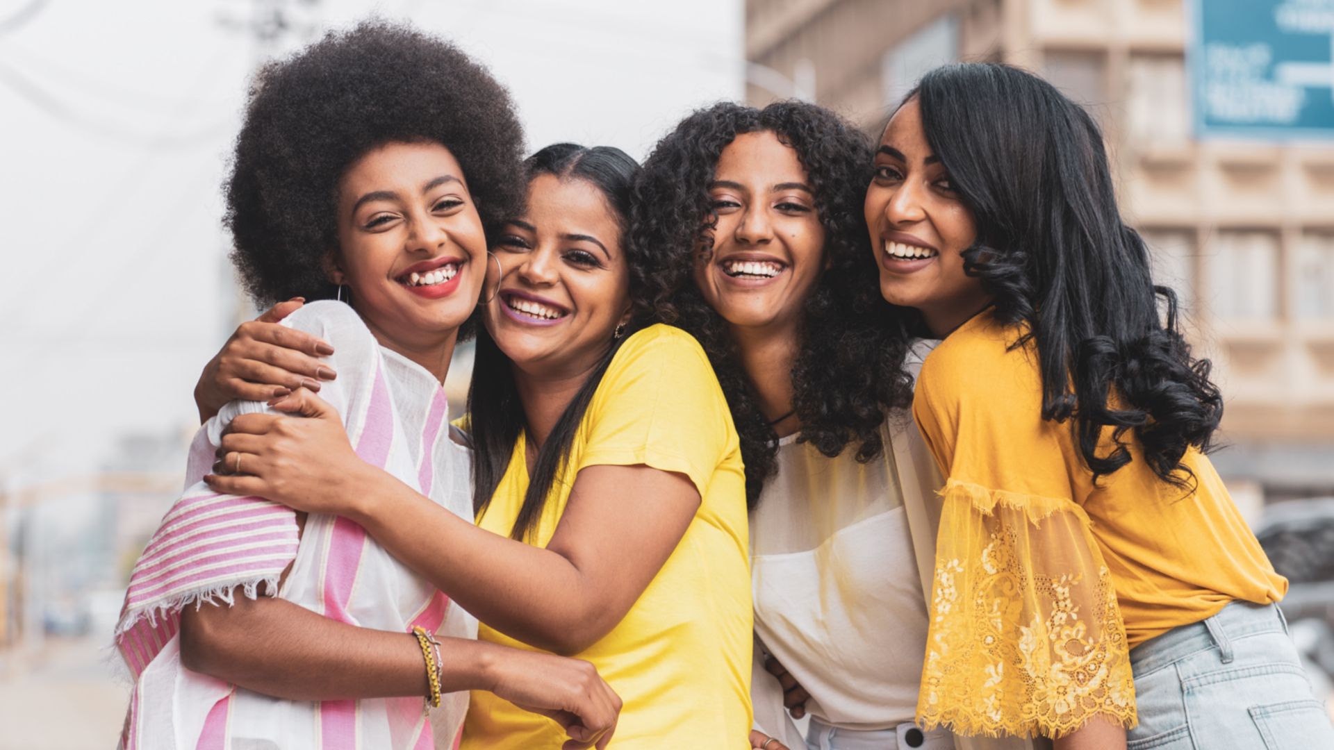 Four Ethiopian women with four different hairstyles comprising straight, curled, styled and natural hair.