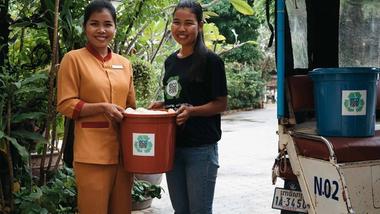 Two women holding a ecosoap bucket