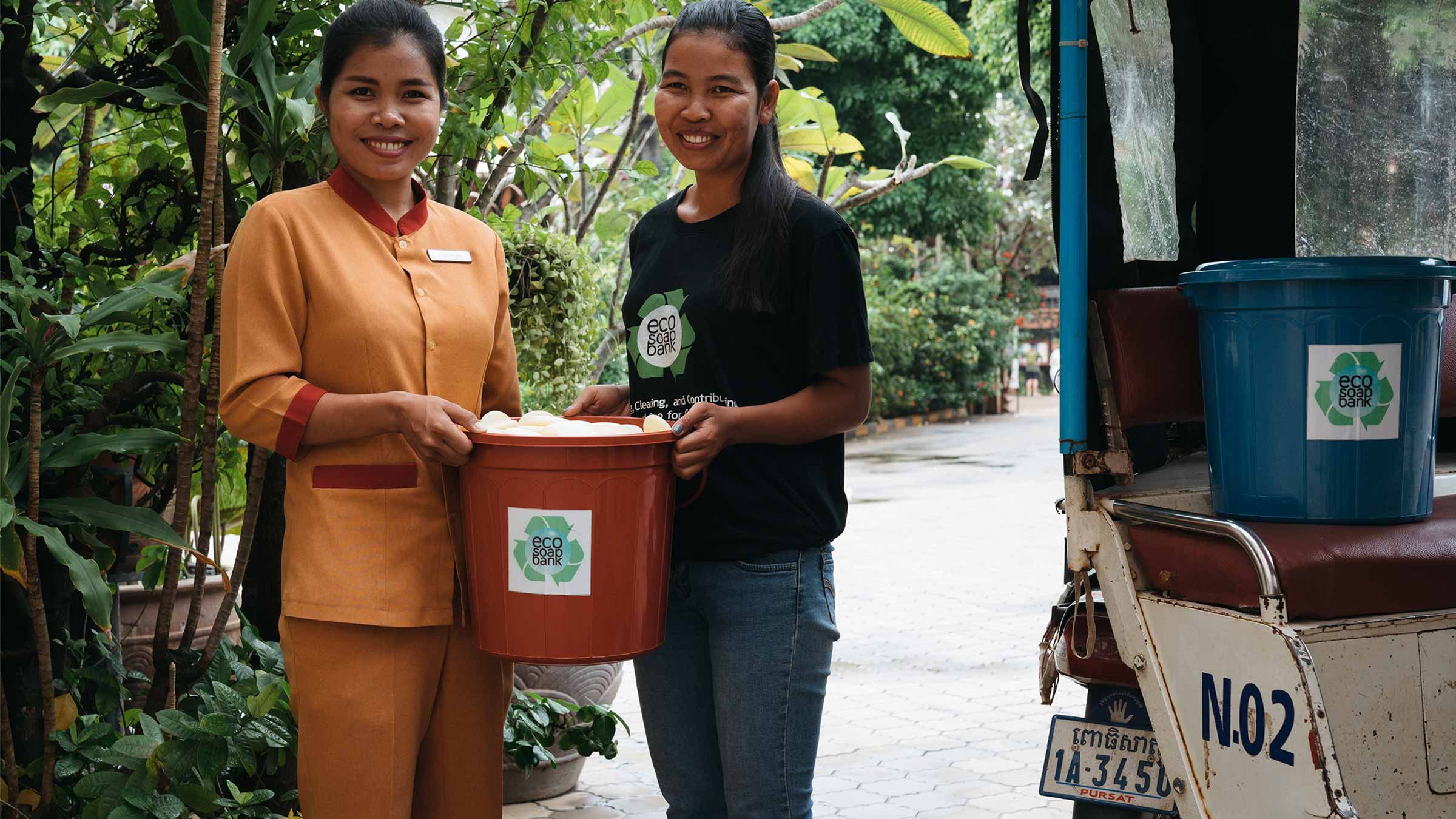 Two women holding a ecosoap bucket