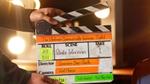 Hands operating a clapperboard 