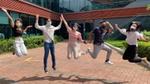 A group of people wearing masks jumping in the air in front of a Unilever office