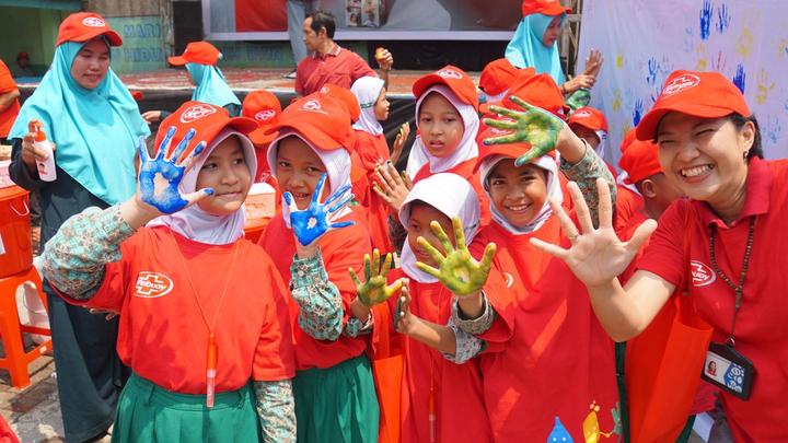 A group of children raise their hands whilst taking part of Lifebuoy’s handwashing programme