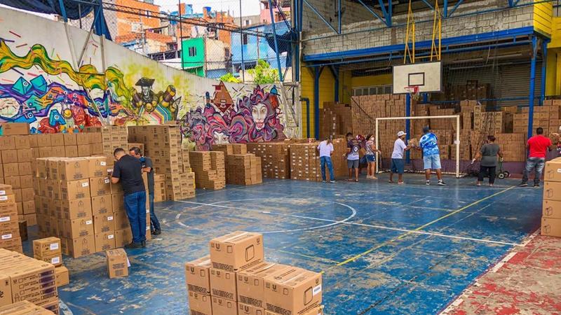 Donations being organised at a basketball court, with a human chain shifting boxes