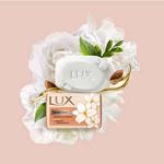 A pack of LUX Velvet soap surrounded by white jasmine flowers on a peach coloured background.