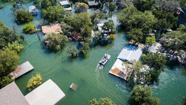 aerial view of flooded village in remote location with trees