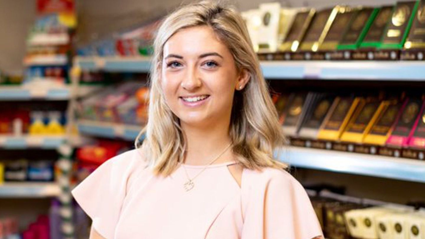 A young apprentice smiling infront of Unilever products