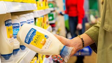 Shopper holding a bottle of Hellmann’s Real Mayonnaise. Hellmann’s sits within Unilever’s Nutrition business group.