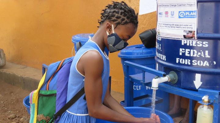 Student girl washing her hands outdoors