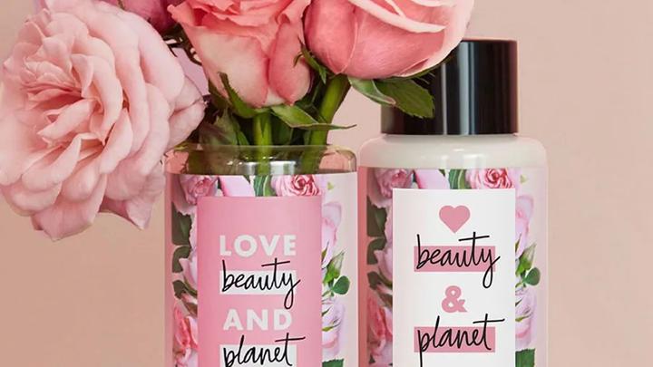 Bottle of Beauty & Planet next to some flowers