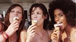 Three women smiling into the camera eating Cornetto ice creams on a sunny day