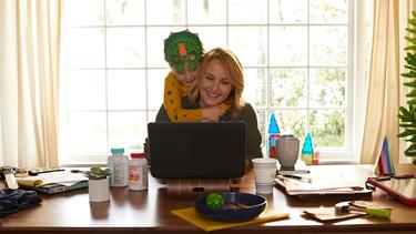 Mother and son hugging in front of a laptop 
