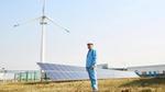 Man standing in front of solar panels and wind turbines at Unilever China factory