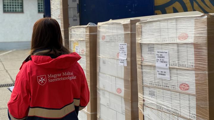 Máltai Szeretetszolgálat munkatársa és dobozos Lifebuoy termékek