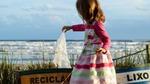 A young girl recycling a plastic bag