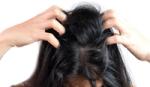 Lady with dark hair scratching head. Unilever research finds bacteria that causes dandruff.