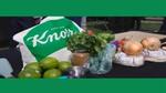 A cloth bag carrying the Knorr logo on a table of vegetables and foods waiting to be cooked