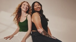 A pic from a Dove ad campaign. Two women sit back to back. One is white with long red hair, one has vitiligo and long dark hair.