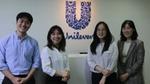 Unilever employees posing in front of Unilever logo
