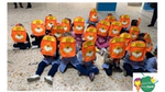 Bambini della scuola elementare di Napoli che coprono il viso con lo zaino del progetto “Sorrisi Previdenti” di Mentadent