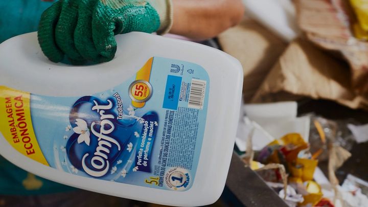 Recycling plant worker in Brazil holding a Comfort bottle