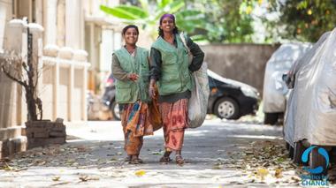 Two waste pickers walking down a street