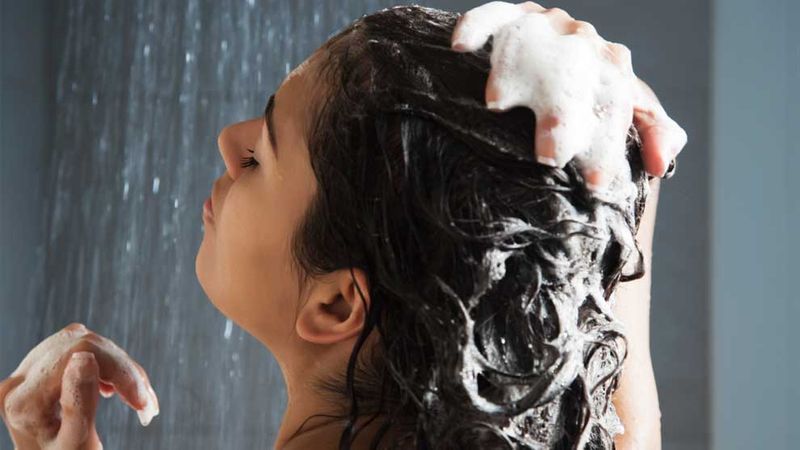 Woman shampooing hair in shower