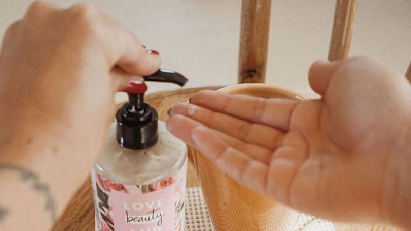 A person using Love Beauty and Planet body lotion