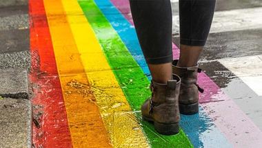Someone walking over a rainbow-painted pavement