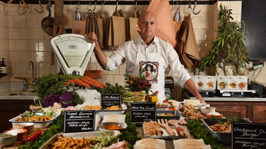 The Vegetarian Butcher surrounded by vegetables, brand products, and a set of weighing scales.