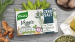 Packet of Knorr Veggie Zero Salt stock cubes on a table surrounded by herbs.