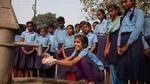 School children washing their hands at an outdoor fountain