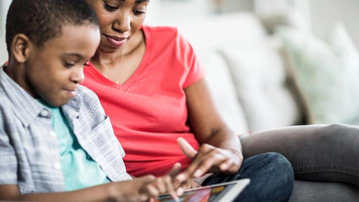 Mother and son working at computer. Hygienica Castle uses online games to teach hygiene lessons to children.