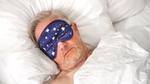 Man asleep with an eye mask on