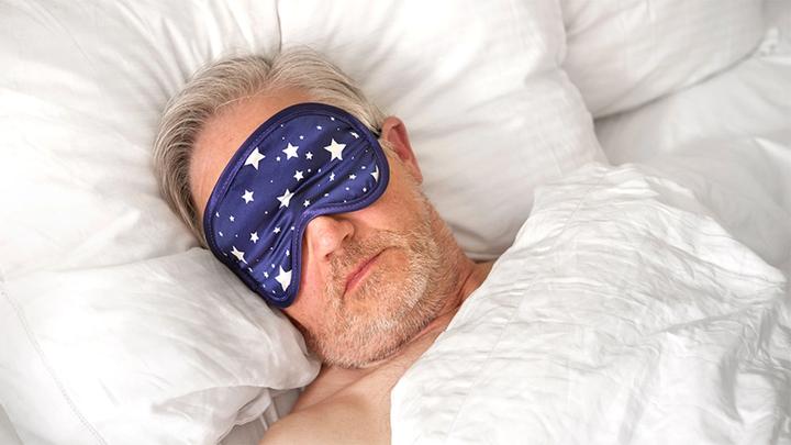 Man asleep with an eye mask on