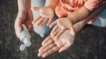 Hands applying hand sanitiser gel