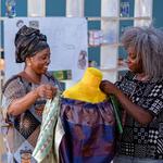 Fashion designer Rebecca Zoro, AWA By Magnum course mentor, discussing a garment with a student in the classroom 