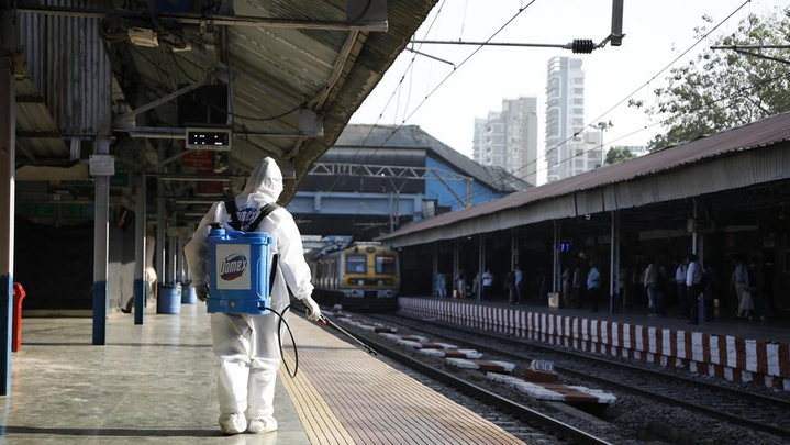 An image of an essential worker spraying Domex sanitizer at a railway station.