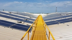 Yellow bridge on top of a building covered in solar panels 