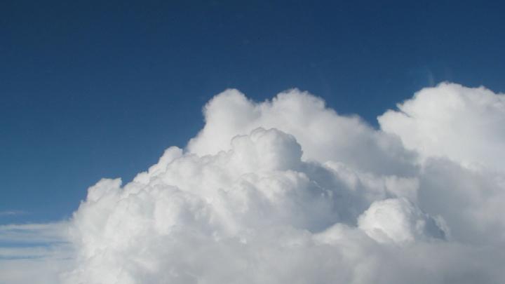 A photo of a blue sky with large white clouds in the foreground