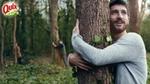 A static shot from a Quix television advert. The photograph features a man hugging a tree.