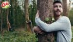 A static shot from a Quix television advert. The photograph features a man hugging a tree.