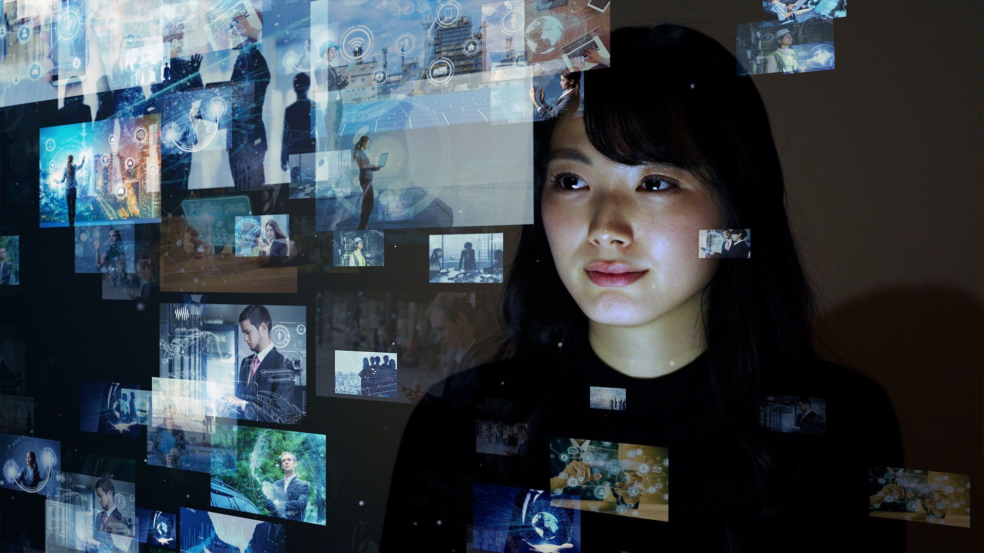 Asian woman viewing many screens of information floating in front of her