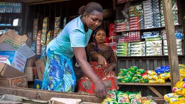 Two women choose Knorr products from a Nigerian market stall